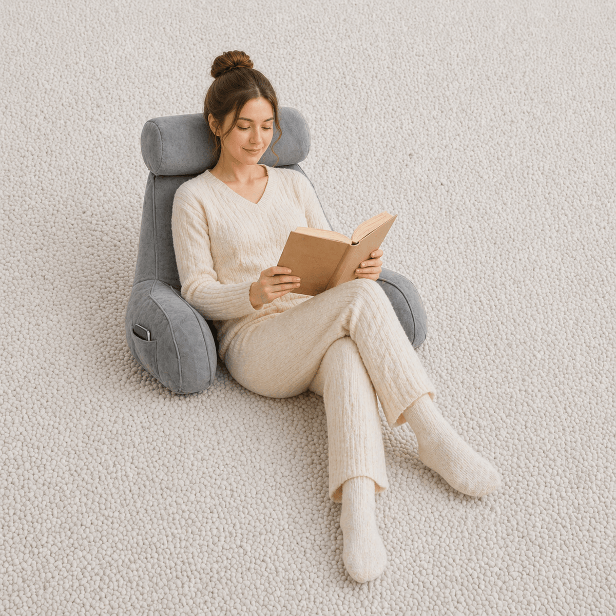 Une femme utilise le Coussin de Lecture à Accoudoirs Gris 