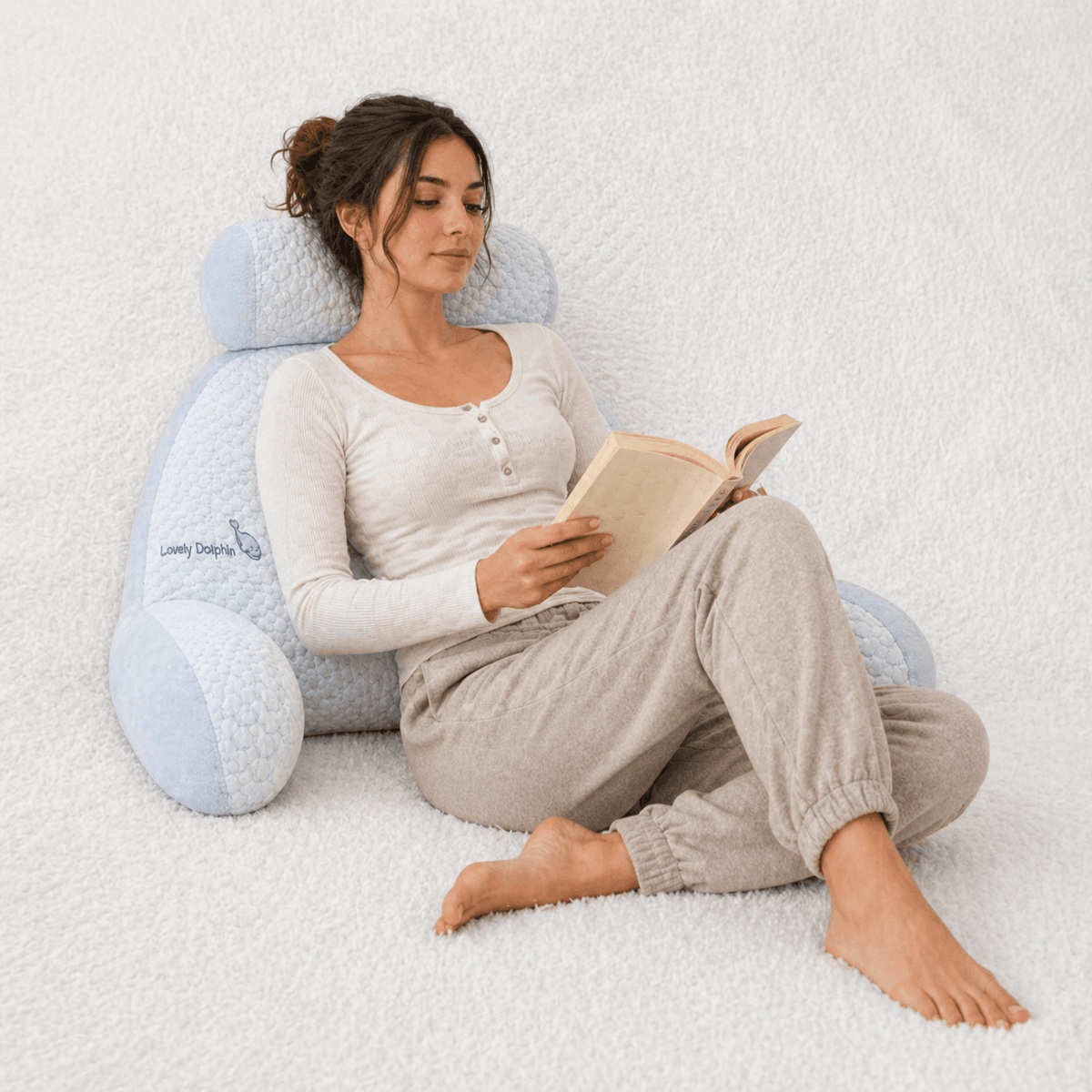 Une femme utilise le Coussin de Lecture Confort Dauphin 