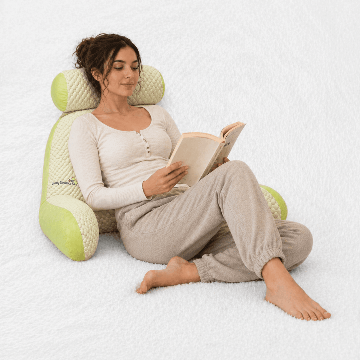 Une femme utilise le Coussin de Lecture Confort Dinosaure 