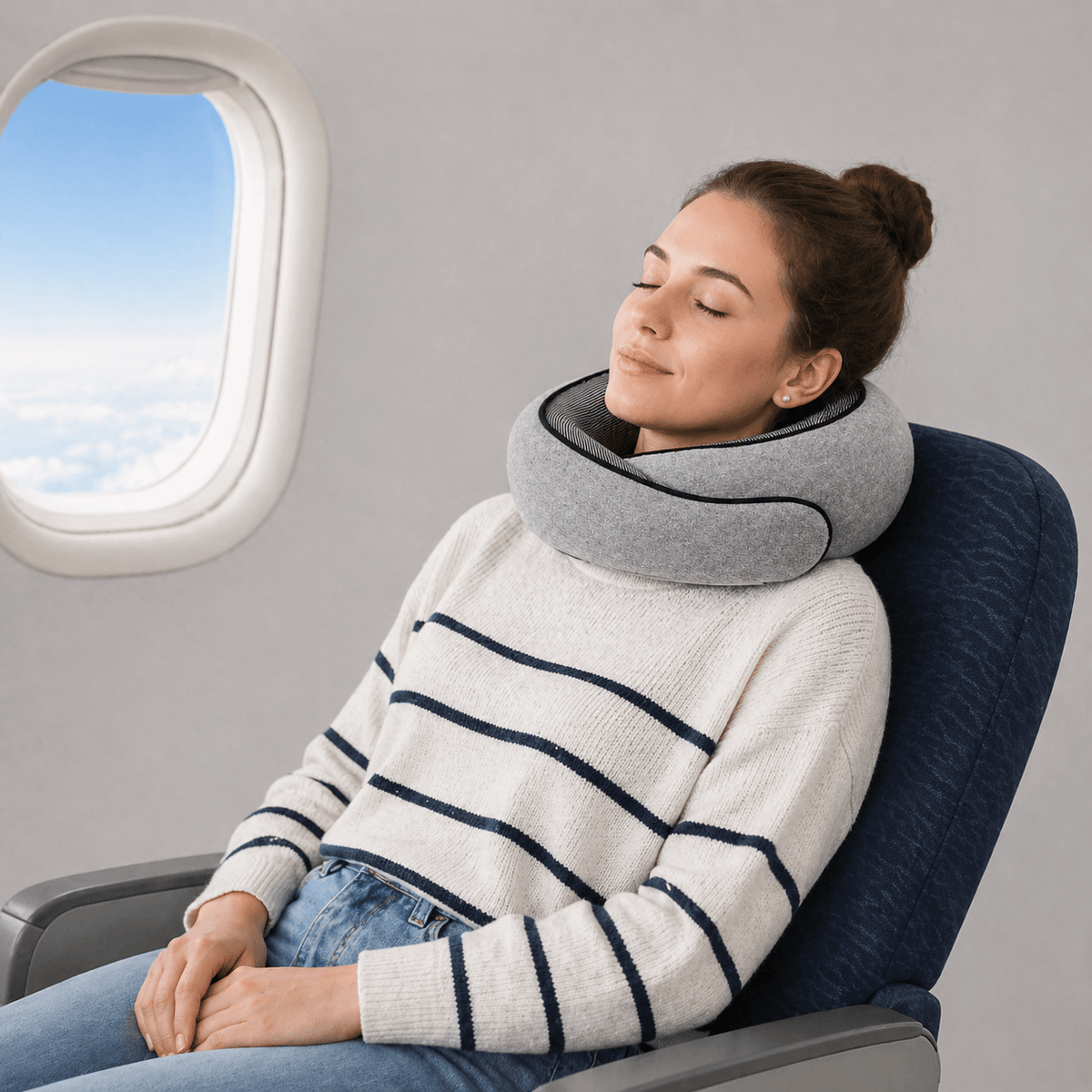 Une femme utilise le Coussin de Voyage Cou gris 