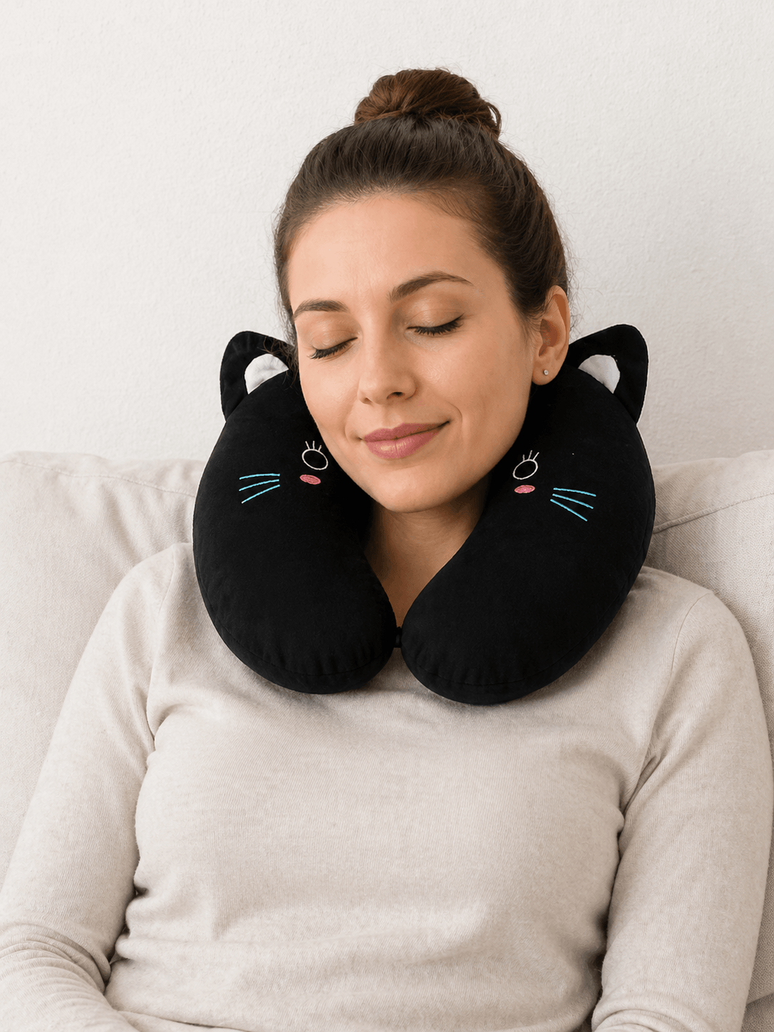 Une femme utilise le Coussin de Voyage chat noir