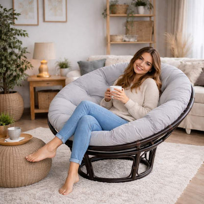 Une femme assise sur le Coussin pour Fauteuil en Rotin rond gris clair