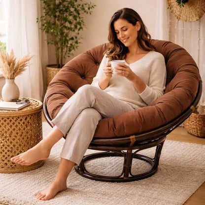 Une femme assise sur Coussin pour Fauteuil en Rotin rond marron