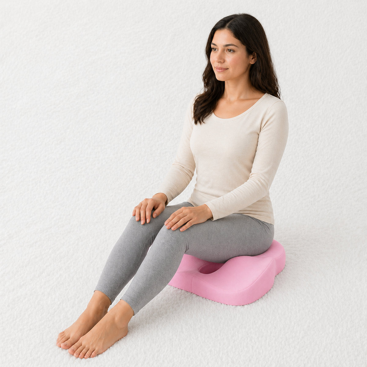 Une femme utilise le Coussin pour Hémorroïdes Orthopédique Rose